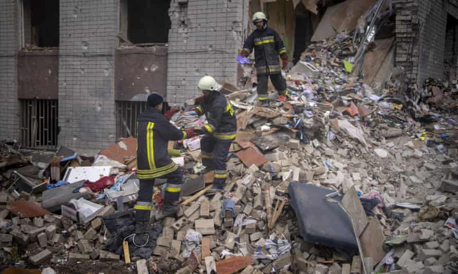 Firefighters carry books after rescuing them from the ruins of a house bombed by Russians in Chernihiv on Friday, April 22, 2022.