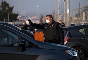 A Customs and Border Protection agent asks drivers to show their documents at the San Ysidro crossing port in Tijuana