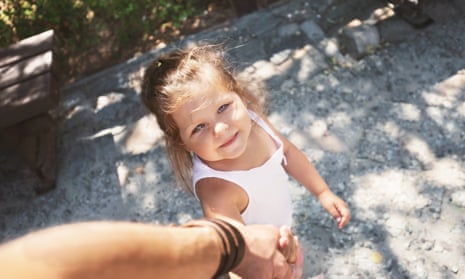 Small girl holding father's hand on a walk