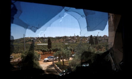 The village of Al Mughayyir photographed through a damaged window after an Israeli settler attack in April 2024.