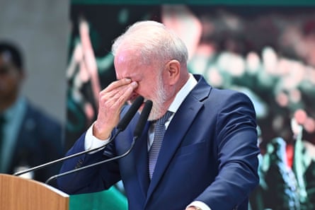 He stands by a microphone and puts his hand to his eyes in distress