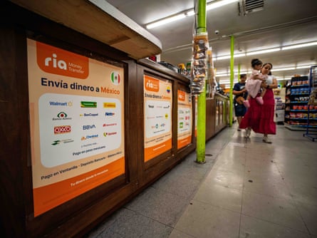 Signs advertising international money transfers are seen as customers walk by