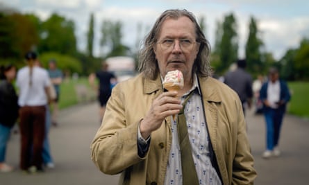 A dishevelled looking Gary Oldman eating a 99 ice cream in a park