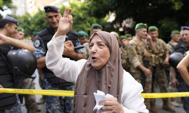 A customer shouts her support outside the bank where Bassam al-Sheik Hussein was demanding his own money.