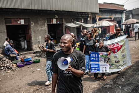 People walking in a market holding banners and megaphone