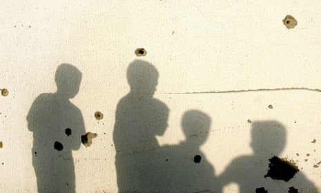 The shadows of palestinian children cast on a bullet riddled wall of a destroyed house in the northern Gaza Strip
