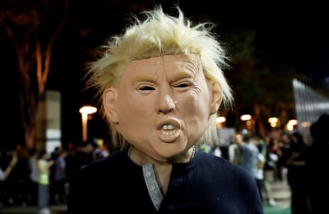 An anti-government protester wearing a mask depicting U.S. President Donald Trump attends a march during Halloween in Victoria Park, Hong Kong, today
