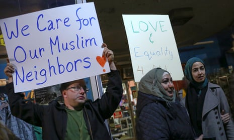 Protesters hold signs during demonstration against President-elect Trump and in support of Muslim residents in Hamtramck, Michigan.