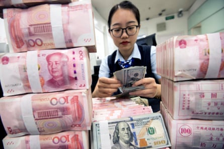 A clerk counts banknotes at a bank outlet in Hai’an, Jiangsu province