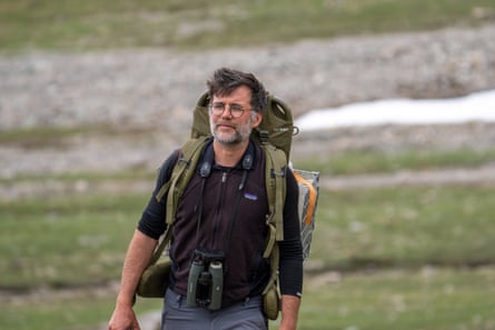 Ecologist Christophe Bonenfant on the mountainside, cage strapped to his back