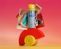 Teenage skincare bottles, earphones, a camera, photos and tickets balance on an arched red block.