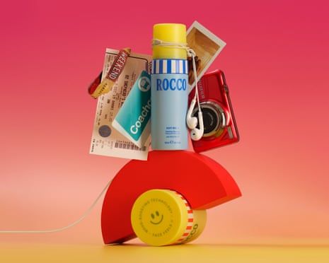 Teenage skincare bottles, earphones, a camera, photos and tickets balance on an arched red block.