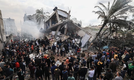 Palestinians gather around a destroyed home following Israeli bombardment of Rafah in the southern Gaza Strip