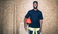Portrait of confident carpentry student holding hardhat while standing against wooden wall<br>“”