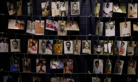 Rows of photographs pegged on to strings showing portraits and family photos of victims