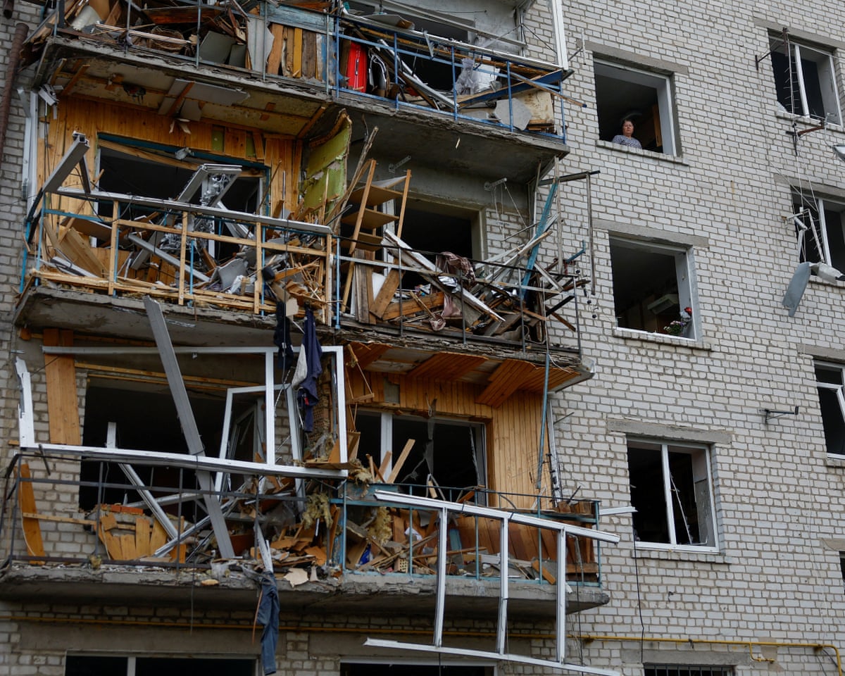 A woman looks out of a window of her apartment damaged by a Russian missile strike in the town of Boryspil, amid Russia’s attack on Ukraine, in Kyiv region, Ukraine.
