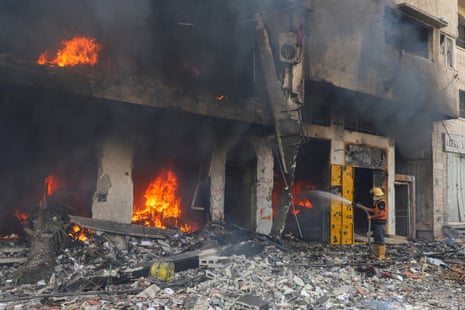 A Palestinian firefighter tries to extinguish fire at a residential building hit in an Israeli strike, amid an Israeli military operation, in Gaza City, earlier today.