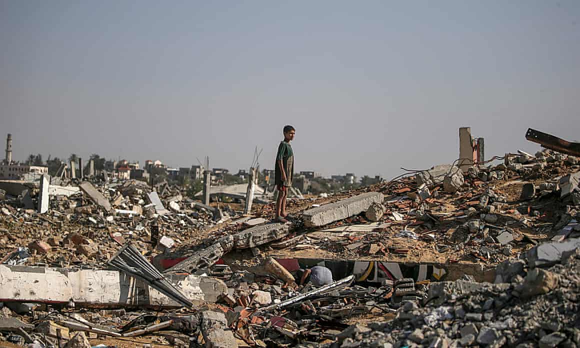 A boy stands amid rubble