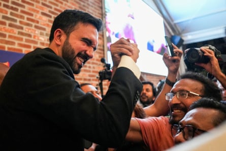 a man in a suit grabs a supporter’s hand