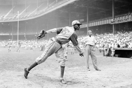 A black-and-white image of Satchel Paige throwing a pitch during a baseball game.
