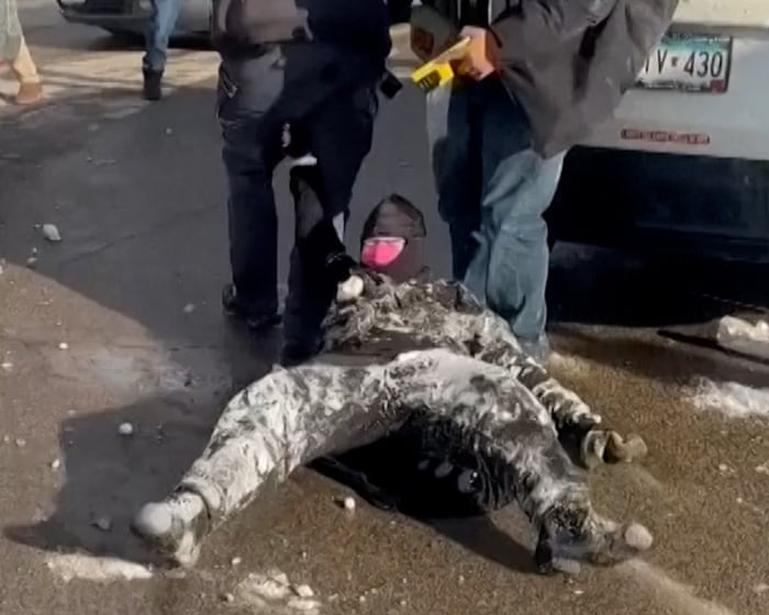 Bystanders throw snowballs at ICE agents dragging woman on the ground in Minneapolis – video