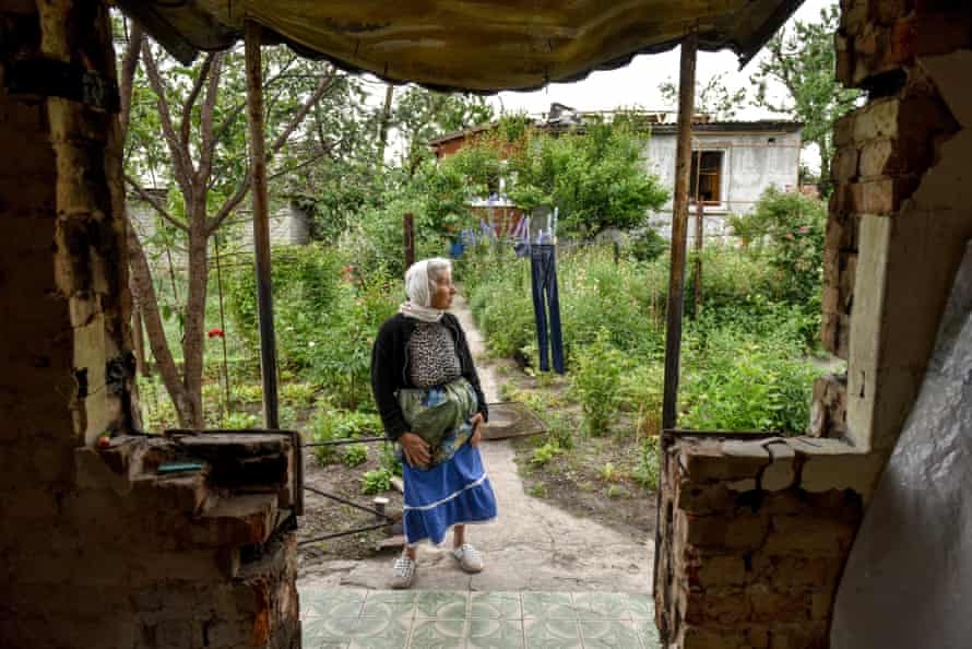 A woman looks on at the remains of her house, destroyed in shelling on Chernihiv city.
