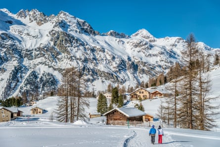 Walking couple in winter landscape in Val Fex in Engadine, Grisons, Switzerland.