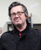 A portrait of Dave McCormack wearing a casual black jacket and glasses