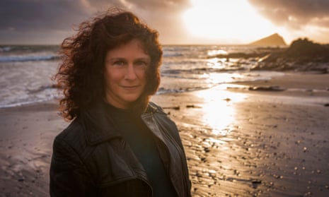 scientist camille parmesan standing on a beach in south-west england with the sun going down behind her