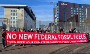 Leaders from the Build Back Fossil Free campaign unfurl a large banner at the United Nations climate summit in Glasgow.