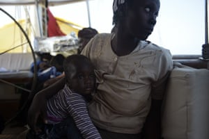 A mother holds her child after being rescued
