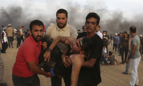 Protesters evacuate a wounded youth from near the fence of the Gaza Strip border.