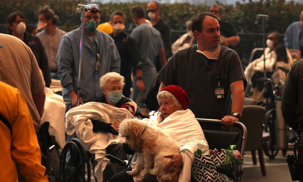 Hospital workers and first responders evacuate patients from the Feather River Hospital in Paradise, California.