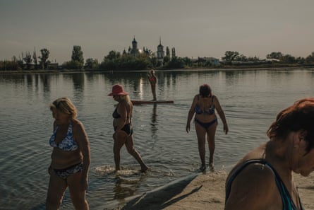 Swimmers paddle in a lake in the frontline Ukrainian city of Sloviansk