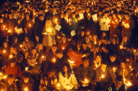A crowd of people holding candles in the dark
