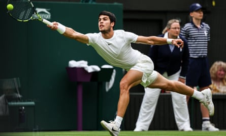 Carlos Alcaraz stretches for a forehand at Wimbledon.