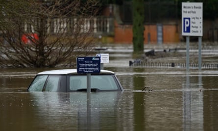roof of a car above flood water with car park sign