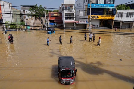 Flood victims wade through a submerged area of Colombo, Sri Lanka, on Sunday.