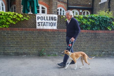 A man with his dog outside a polling station in Wimbledon this morning.