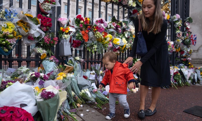18-month-old George Tate from London is shown flowers and tributes by his mother as they visit Buckingham Palace.