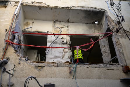 Construction workers begin removing debris after a projectile destroyed a Tel Vaiv apartment.