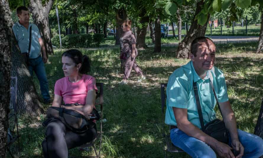 Worried parents who fear their loved ones were inside the building wait opposite the mall.