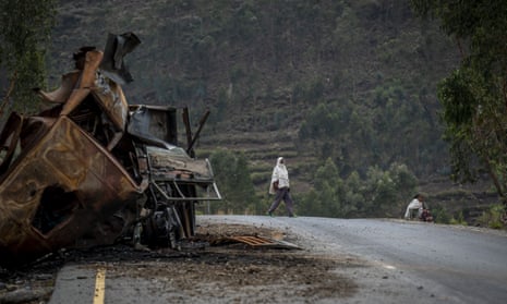 A man crosses a road near a destroyed truck on a road leading to the town of Abi Adi, in the Tigray region of northern Ethiopia, in May 2021
