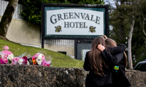 Students from Holy Trinity College leave floral tributes outside Greenvale hotel in Cookstown, County Tyrone.