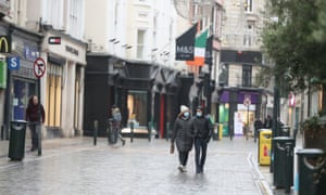 People walk along a deserted Grafton Street in Dublin city centre as Ireland remains in lockdown to help prevent the spread of coronavirus.