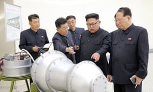 Kim Jong-un inspects a device, or perhaps a model of a bomb, in front of a diagram suggesting its size may be small enough to fit into an ICBM. Photograph: KCNA/EPA