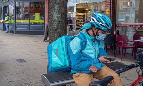 A deliveroo rider wearing a facemask in Wimbledon town centre.