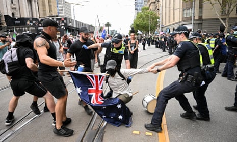 Police remove a protester during a transgender rights rally, involving opposing neo-Nazi protesters, outside Parliament House in Melbourne