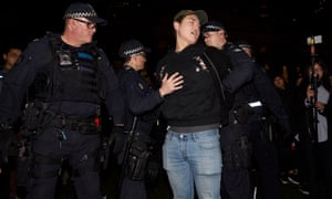 Police detain a man during a rally at the State Library in Melbourne