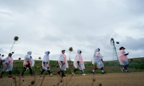 Women walking on a country road wearing rain ponchos 